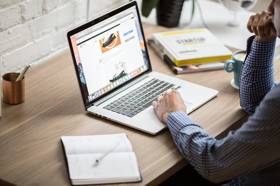 Man working on MacBook air on desk.