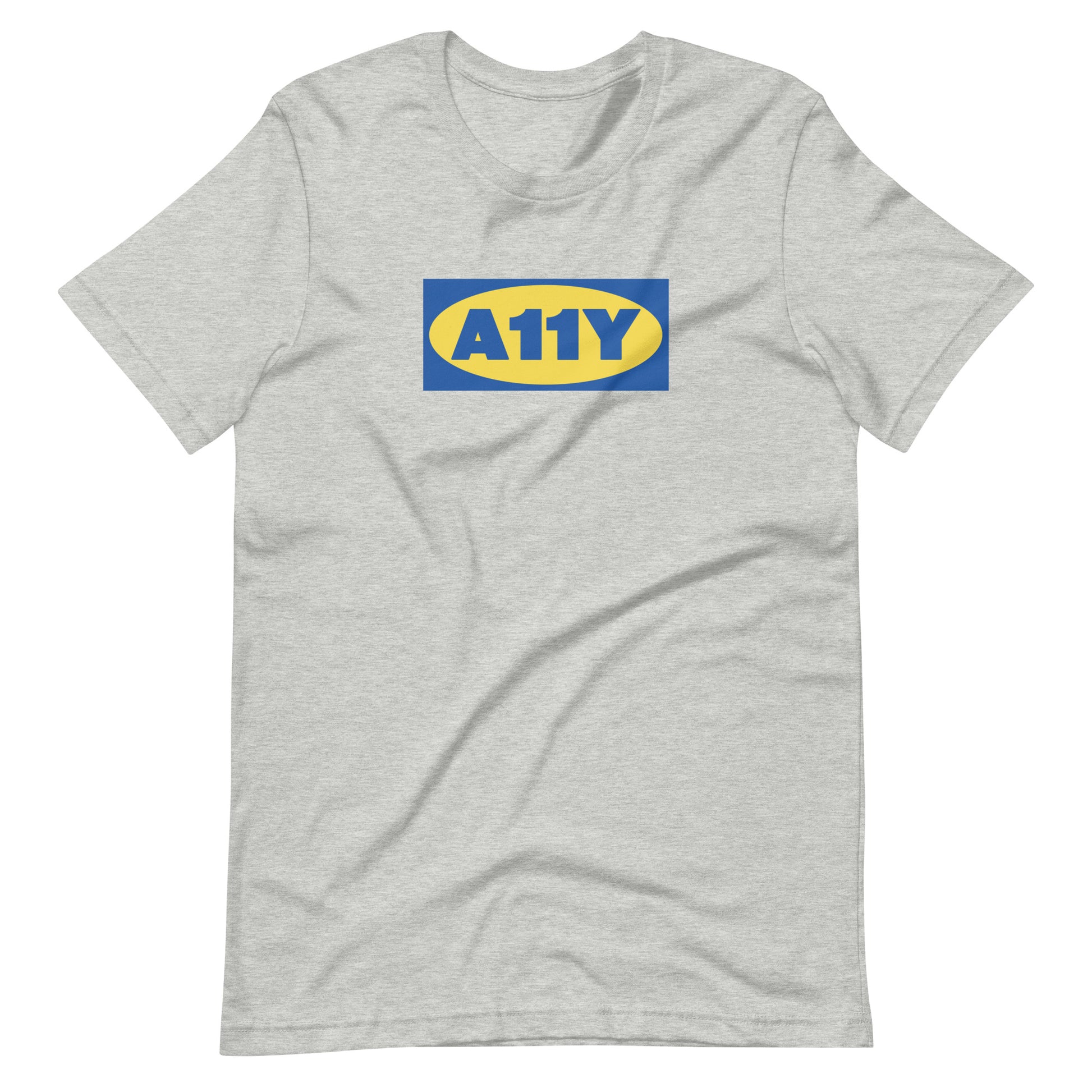 Thick blue A11y letters, on top of a yellow oval, on top of a blue rectangle. Remicent of the Ikea logo. Center aligned on front of a heather grey t-shirt.