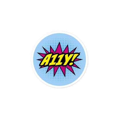 Comic book style logo. Bold, yellow A11Y! lettering with black outline on top of magenta star burst. Background is light blue halftone (dots), 3 inch round sticker.