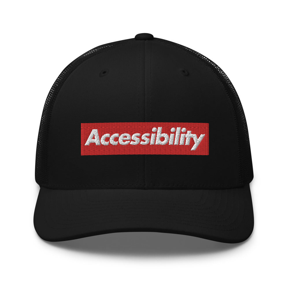 White, bold, slightly italic Accessibility word on red background, on black trucker hat with black mesh backing.
