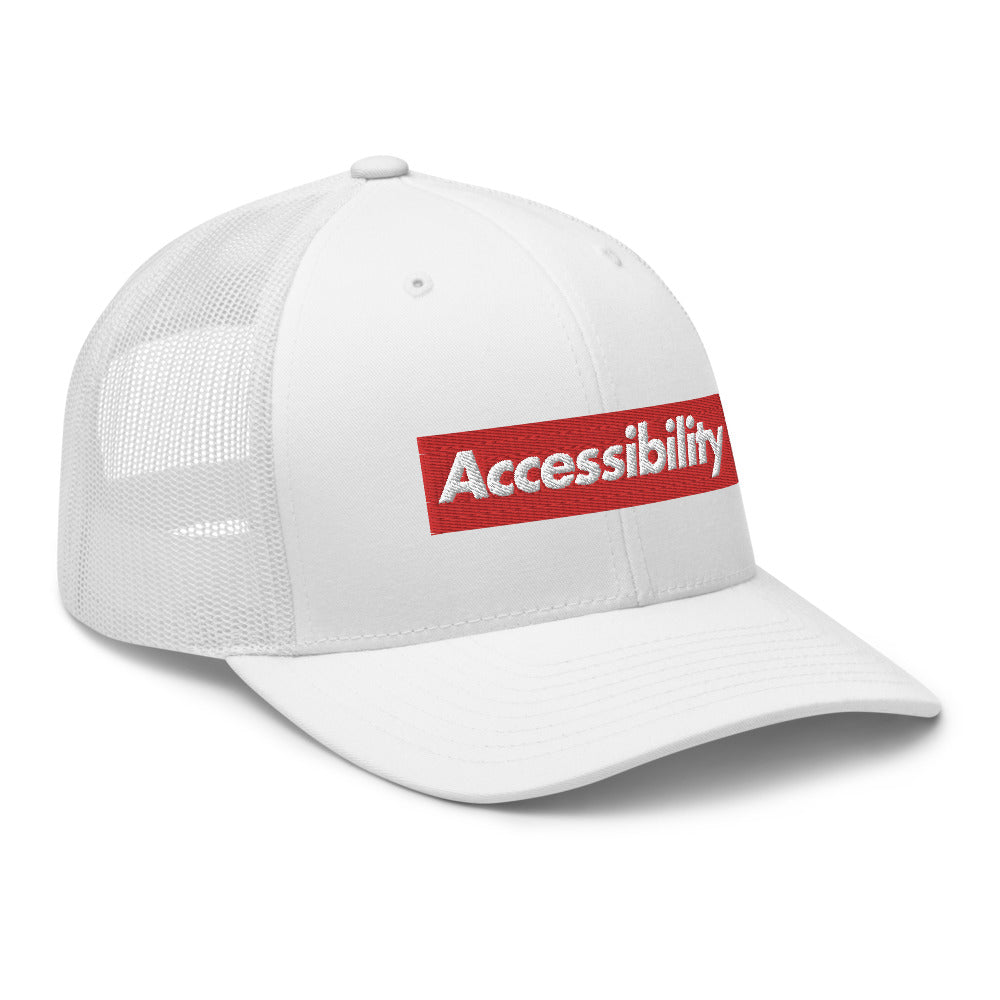 Angle view of all-white trucker hat shows text logo design on front of hat with mesh backing.