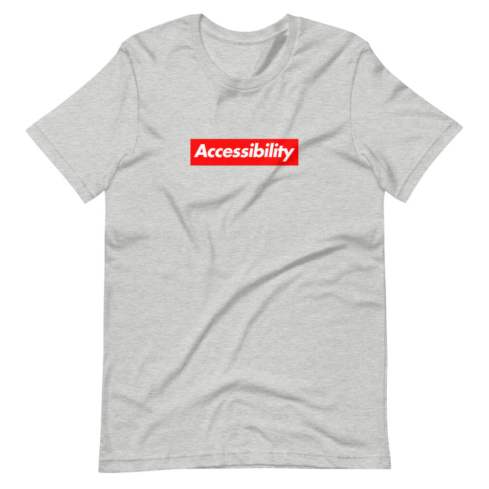 White, bold, slightly italic Accessibility word on red background, on heather grey t-shirt.