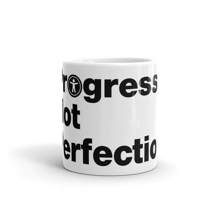 Black, Progress Not Perfection, words, stacked, left aligned. 'O' in Not is round universal icon, on front of white coffee mug, middle side view.